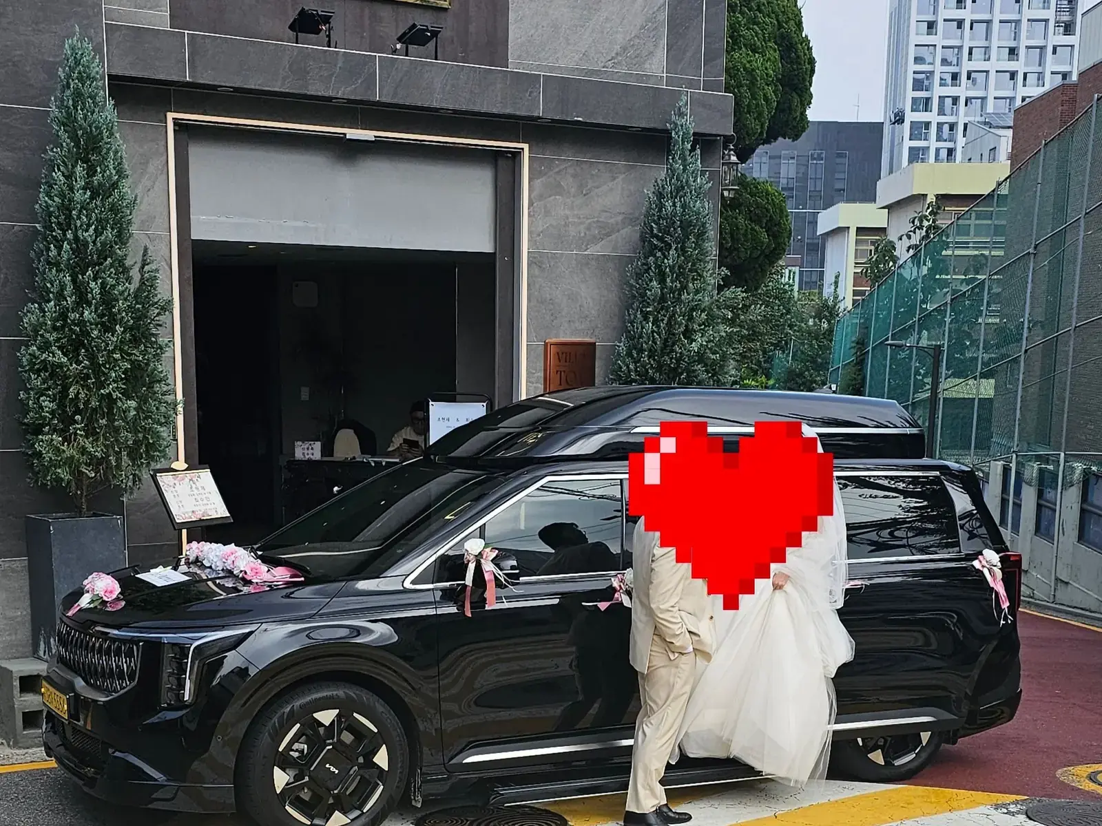 예식장 앞에 꽃으로 장식하고 대기 중인 웨딩 차량